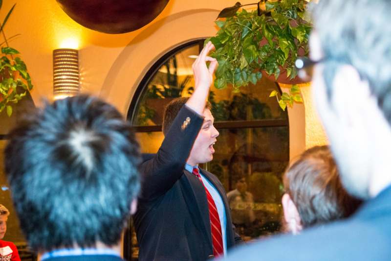 a man in a suit raising his hand