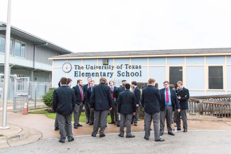a group of people standing in front of a school