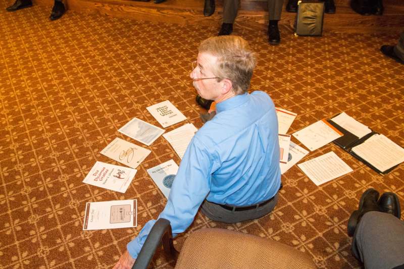 a man sitting on the floor with papers on the floor