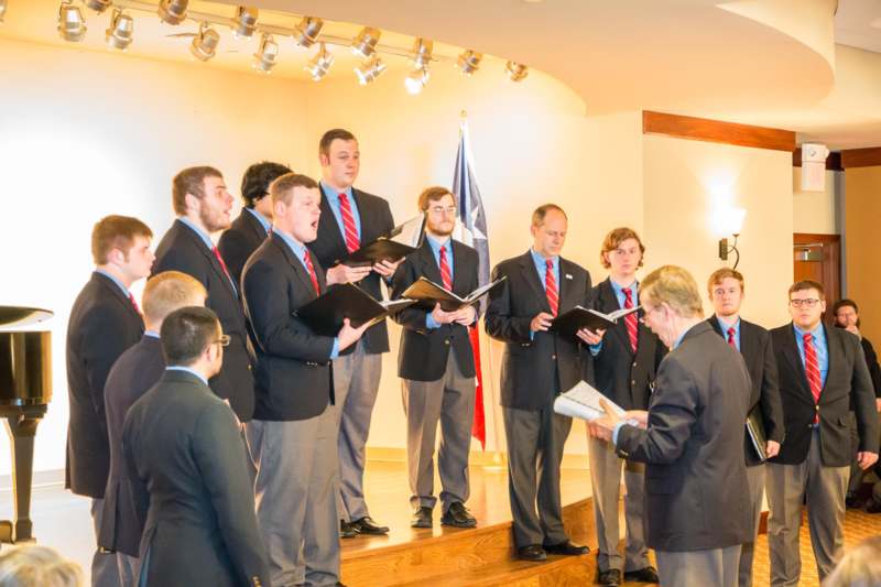 a group of men singing in a room