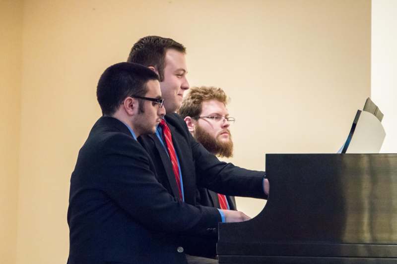 a group of men playing a piano