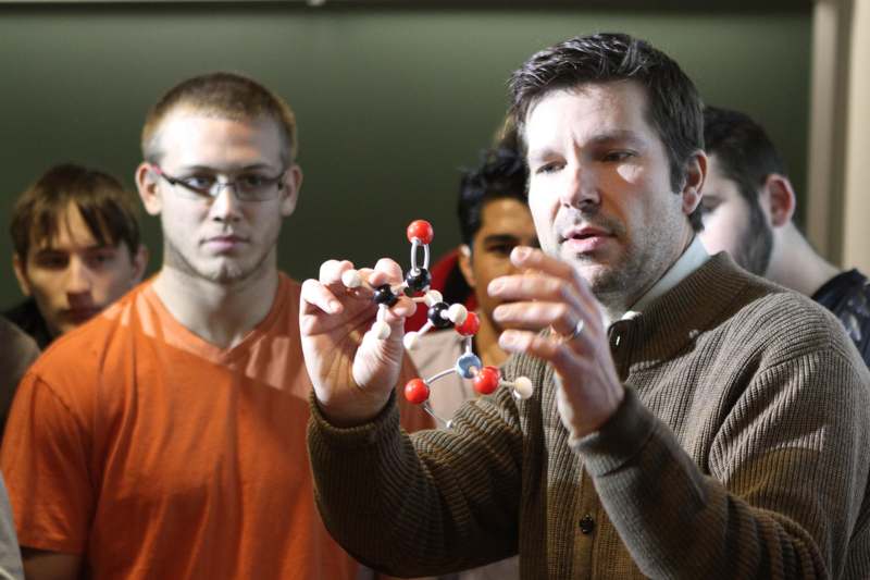 a man holding a model of a molecule