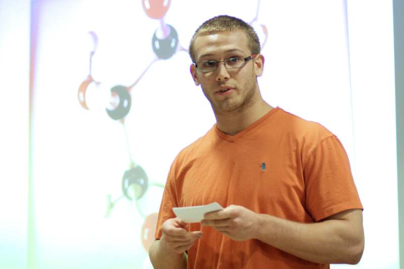 a man in an orange shirt holding a piece of paper
