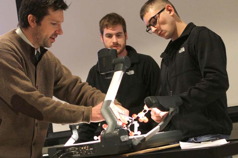 a group of men looking at a machine