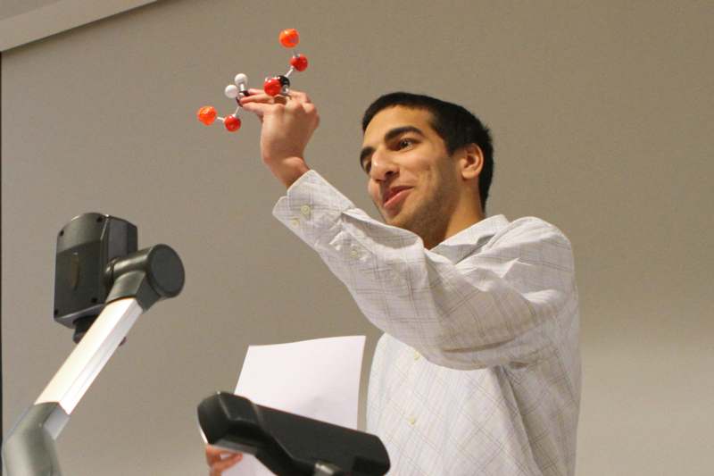 a man holding a model of a molecule