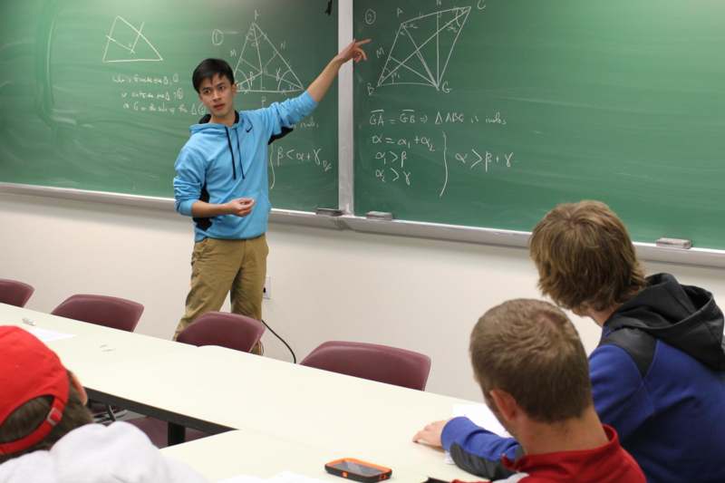a man pointing at a chalkboard