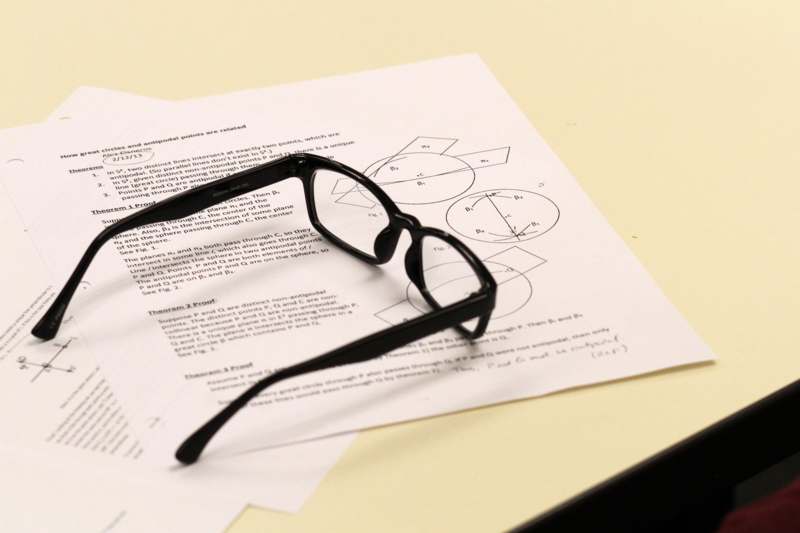 a pair of black glasses on a piece of paper