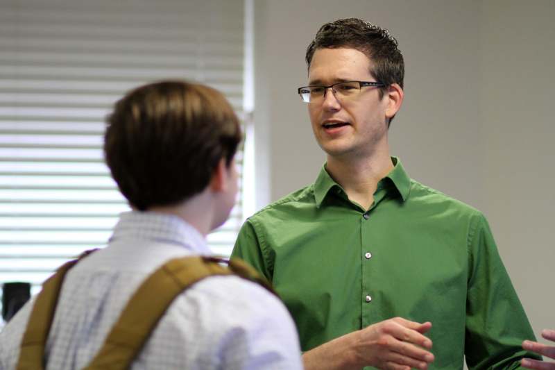 a man in a green shirt talking to a boy