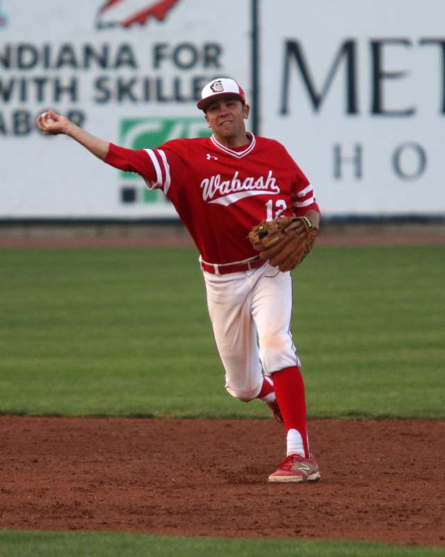 a baseball player in red and white uniform throwing a baseball