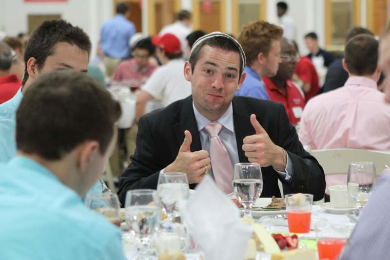 a man giving thumbs up at a table