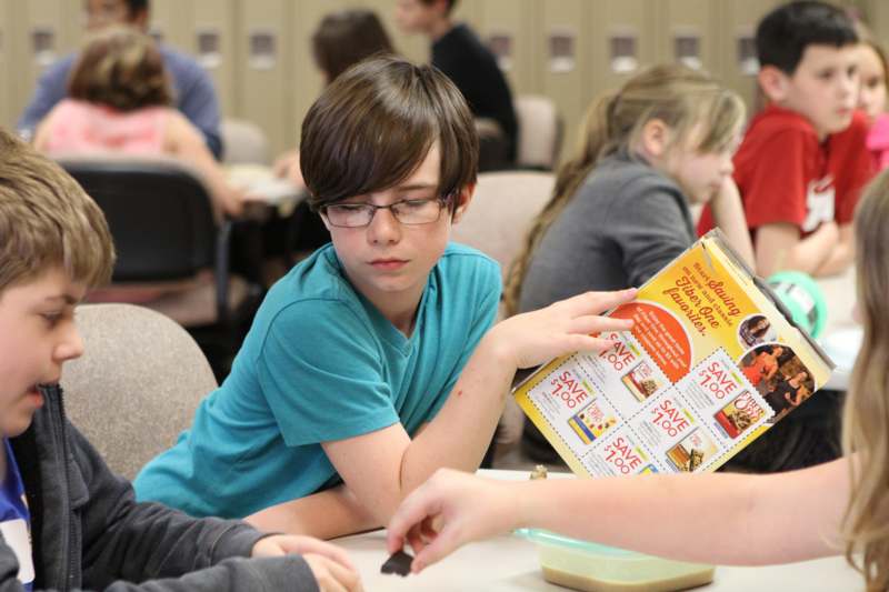 a boy reading a book at a table