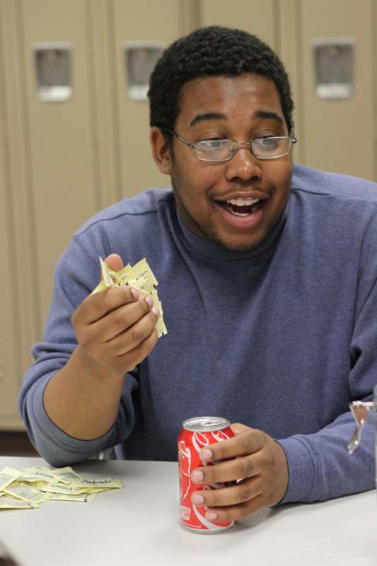 a man holding a soda and a piece of paper
