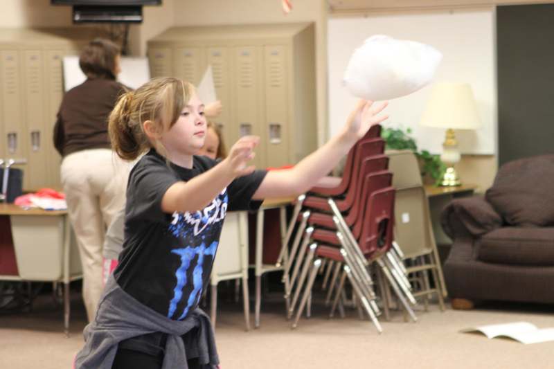 a girl throwing a white object in the air