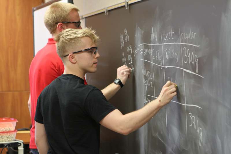 a group of men writing on a chalkboard