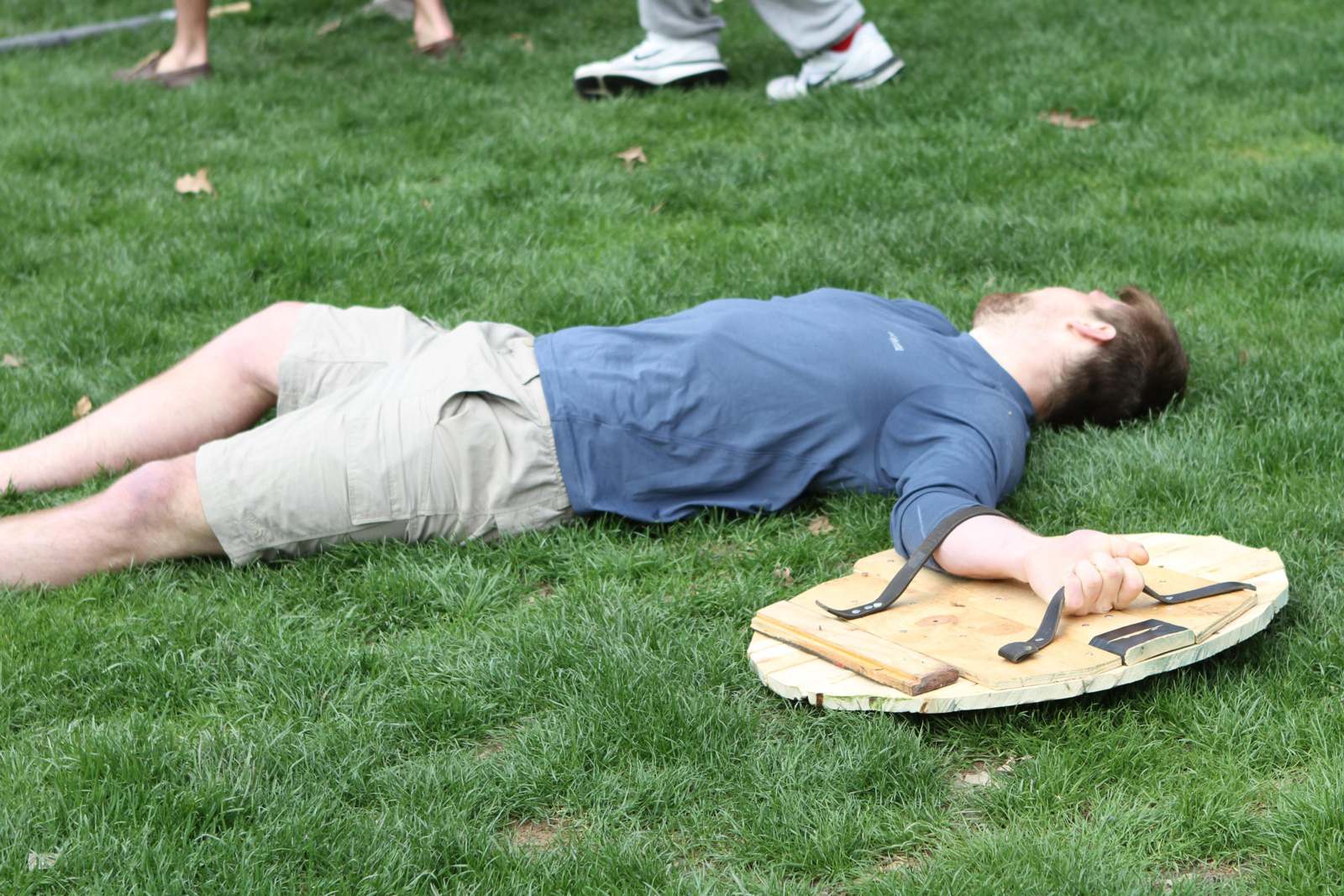 a man lying on the ground with a wooden board