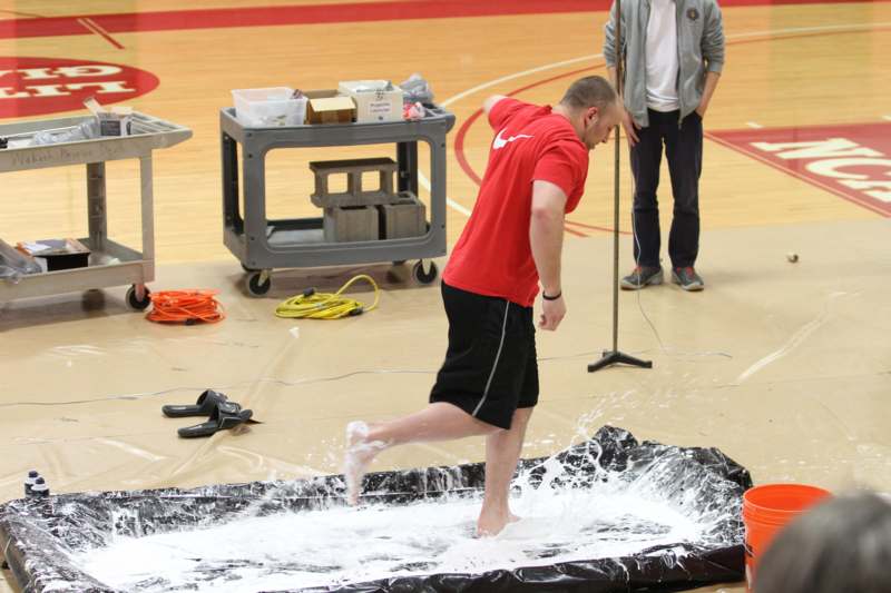 a man standing on a rubber pad with white liquid on it
