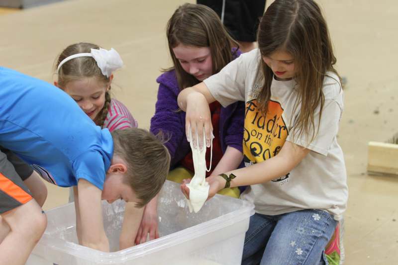 a group of kids playing with a slime