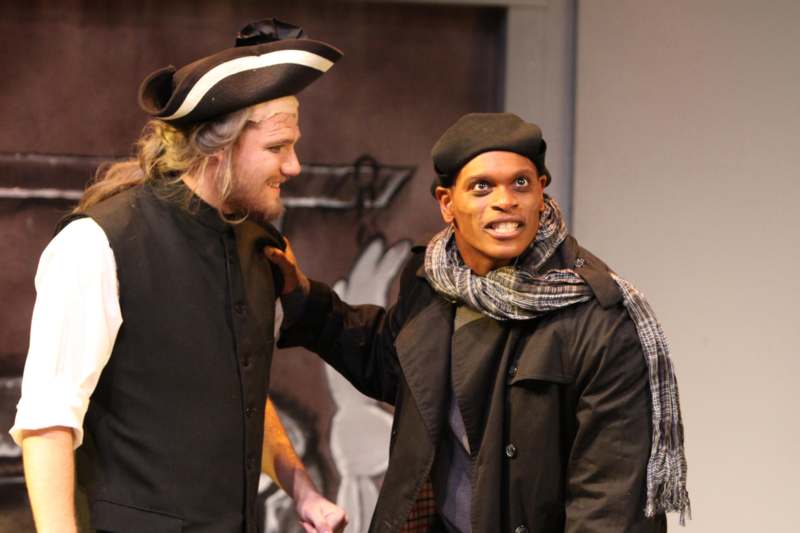 a man in a hat and scarf holding another man in a hat