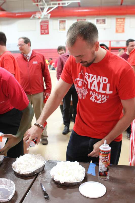 a man in red shirt pouring whipped cream into a bowl