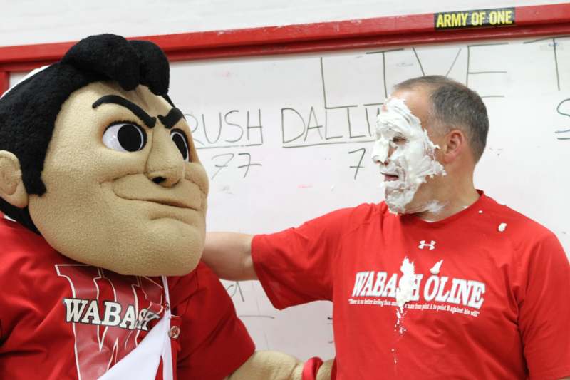 a man in a red shirt with a mascot on his face
