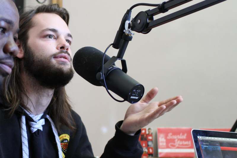 a man with a beard talking into a microphone