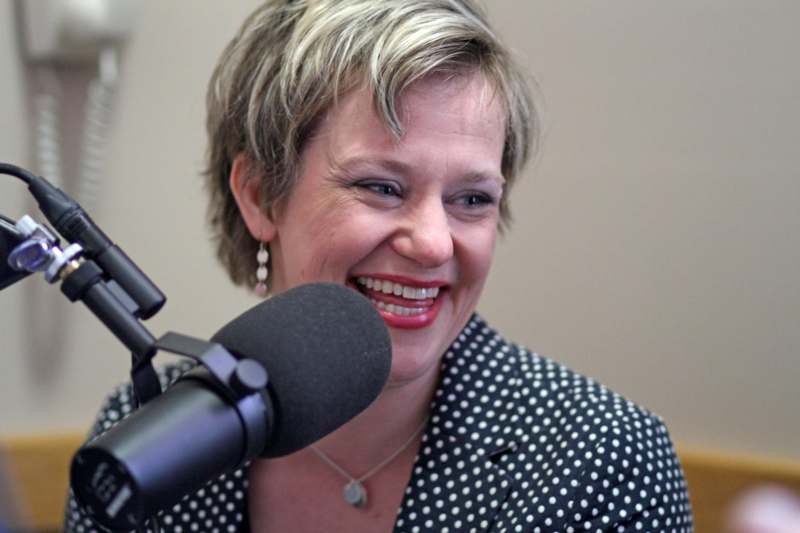 a woman smiling at the microphone
