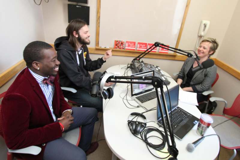 a group of people sitting around a table with a microphone and a microphone