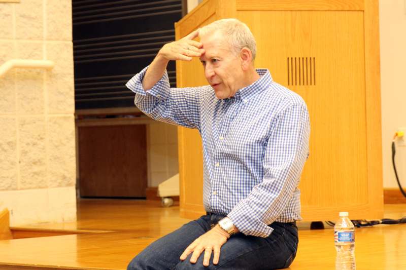a man sitting on a wooden surface