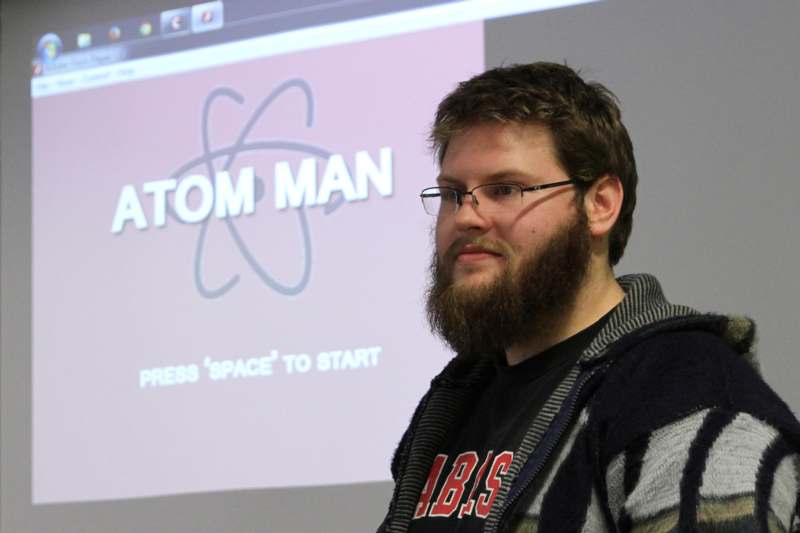 a man with a beard in front of a screen