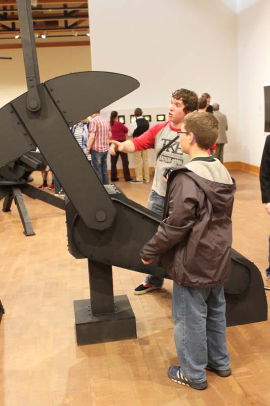 a group of people looking at a large black machine
