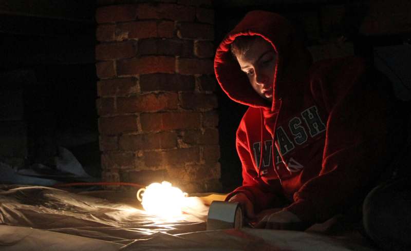 a person in a red hoodie looking at a light