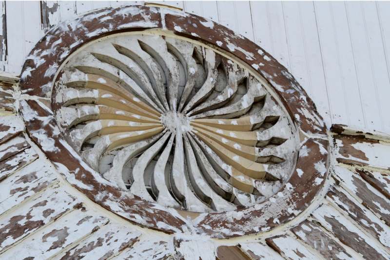 a circular wood carving on a white wall