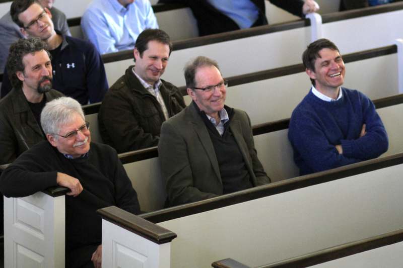 a group of men sitting in pews