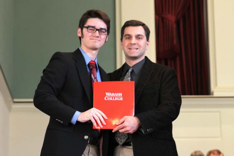 a couple of men holding a red folder