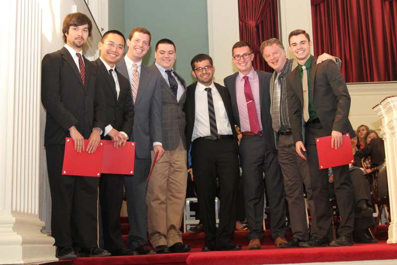 a group of men standing on a red carpet