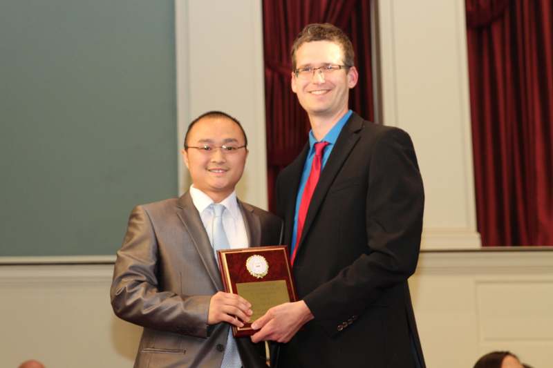 a man holding a plaque with a man in a suit