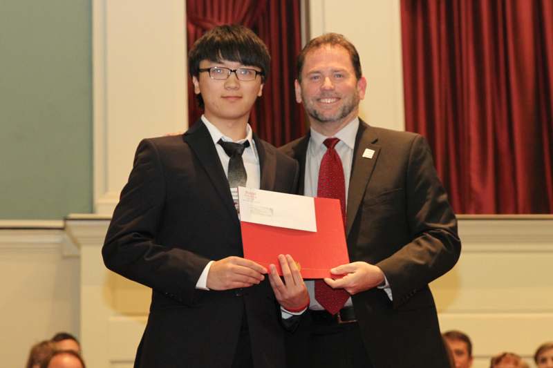a man in suit holding a red folder with a man in a suit