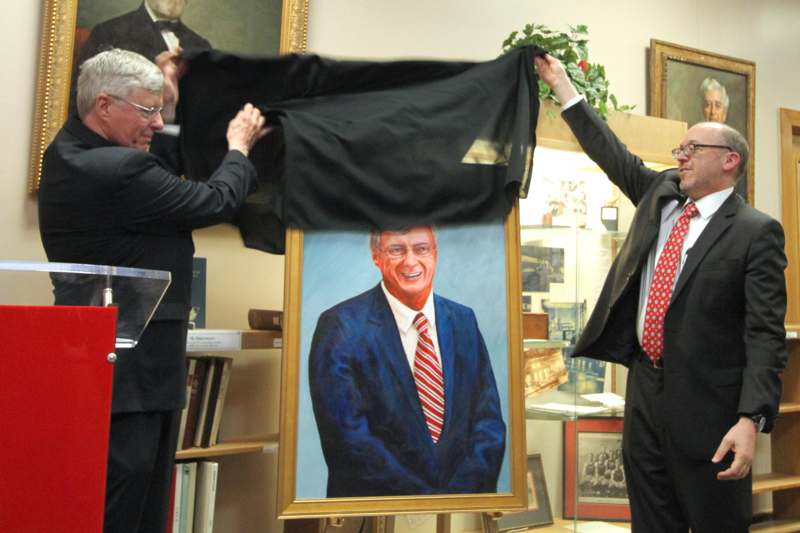 a man holding a piece of cloth over a painting