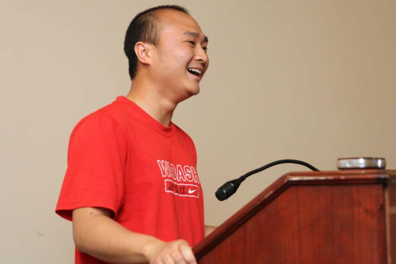a man standing at a podium smiling