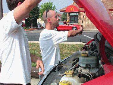 a man looking at a car engine