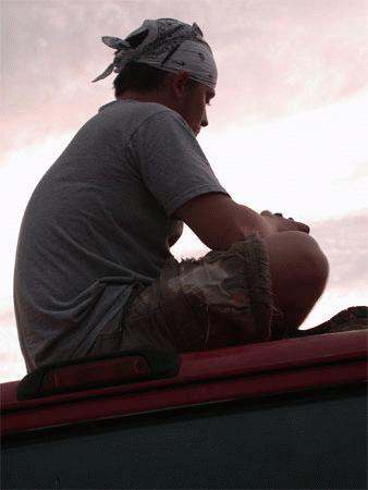 a man sitting on the roof of a car