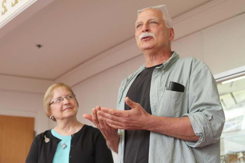 a man and woman standing in front of a white wall