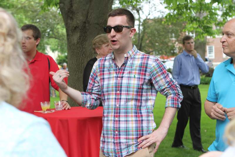 a man in sunglasses standing in a park