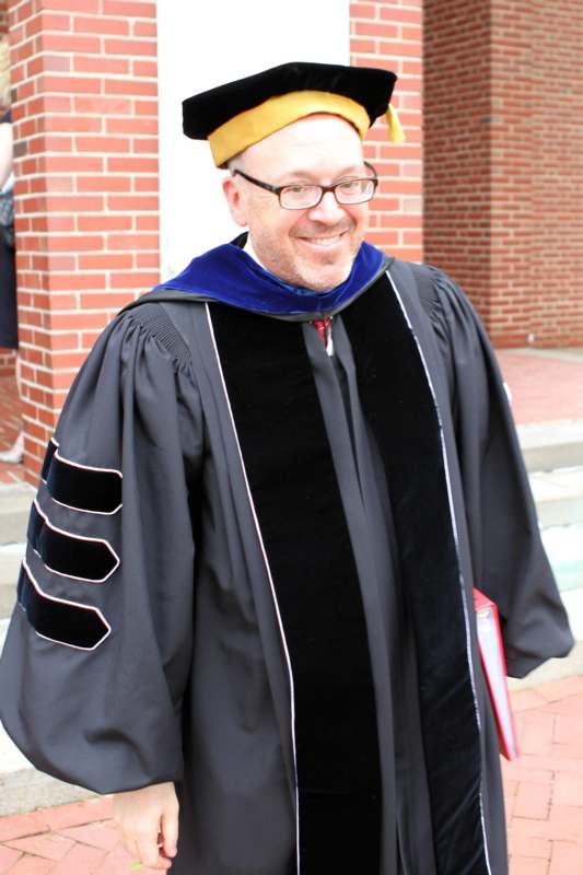 a man wearing a graduation gown and hat