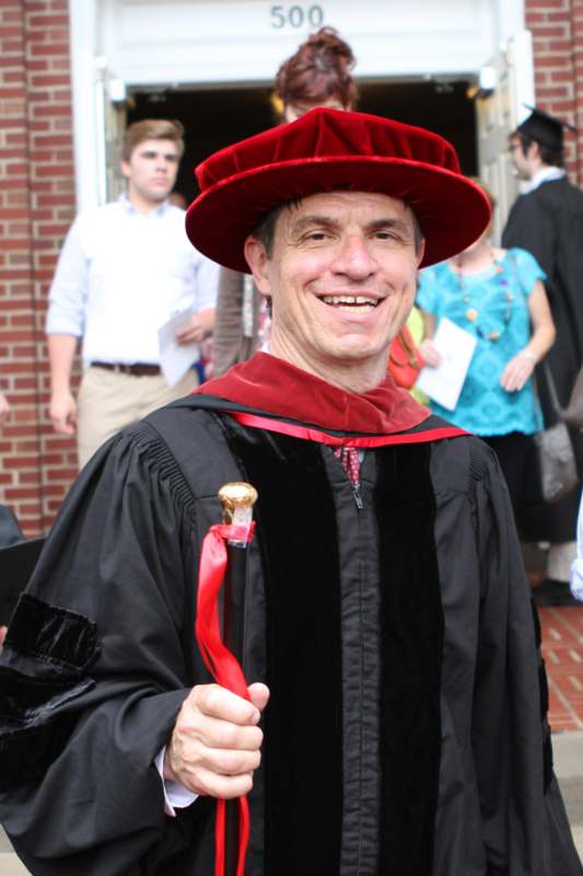 a man wearing a red hat and robe