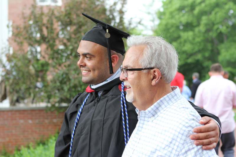 a man in a cap and gown with his arm around another man