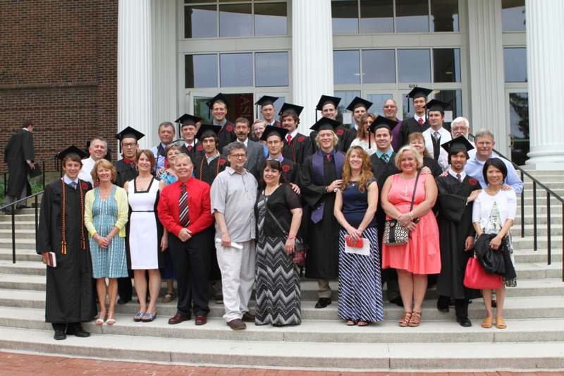 a group of people in graduation gowns and caps posing for a photo