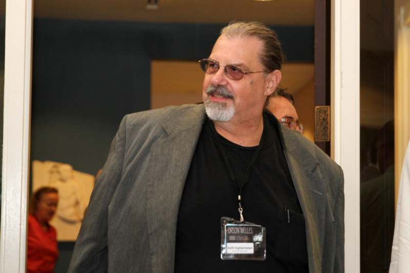 a man wearing a lanyard and a grey jacket