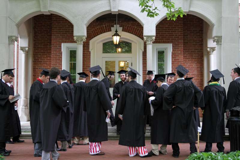 a group of people in graduation gowns outside a building