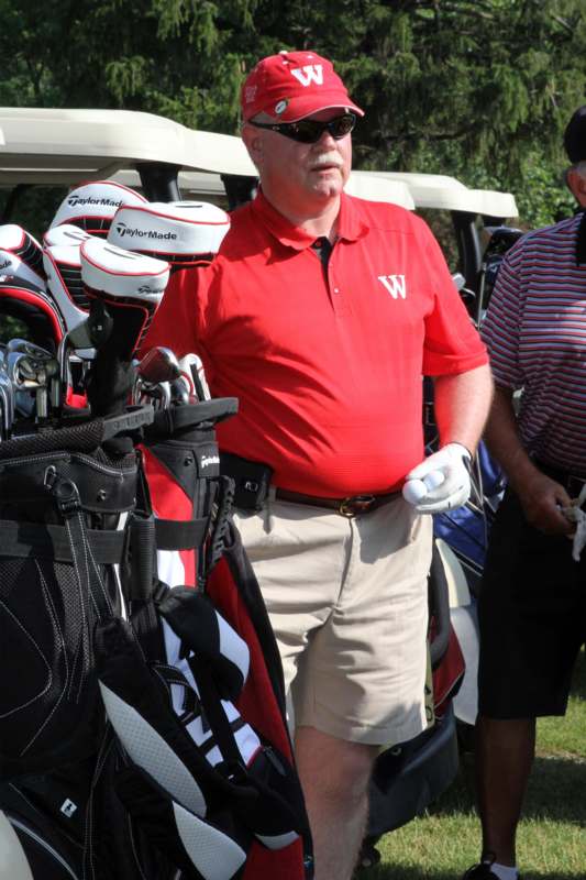 a man standing next to a golf bag